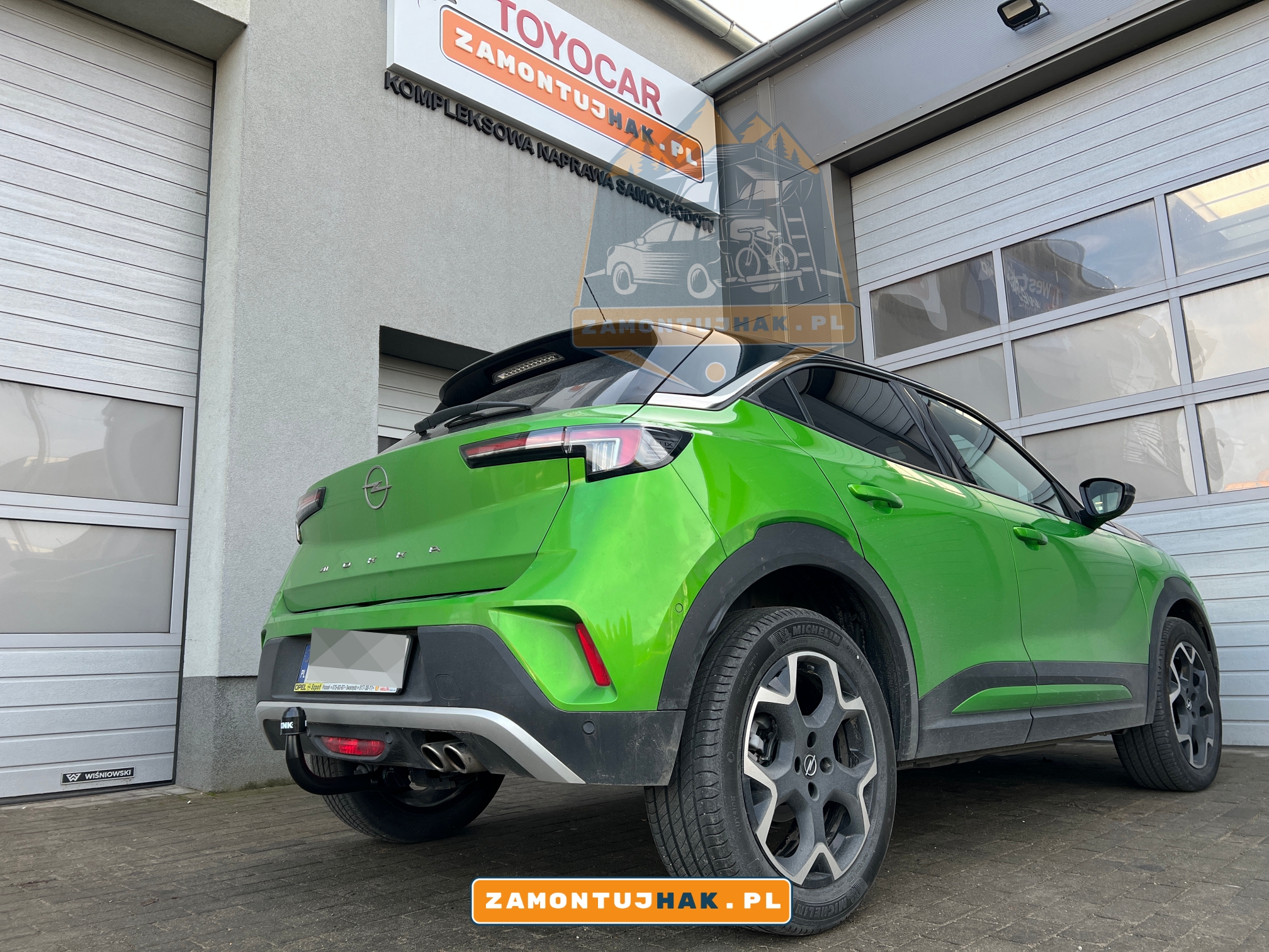 Zdjęcie Opla Mokki z zamontowanym hakiem holowniczym Westfalia A40V, zdjęcie zrobione z prawej strony samochodu, z bliska, na tle serwisu